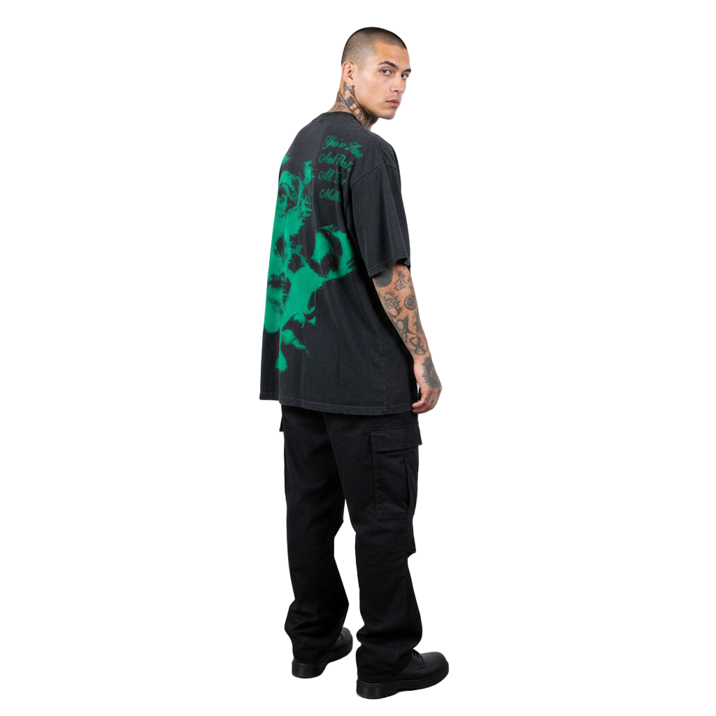 Man wearing a black t-shirt with green graphic design and black pants on a white background